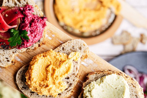 Verschillende soorten hummus op een plakje stokbrood