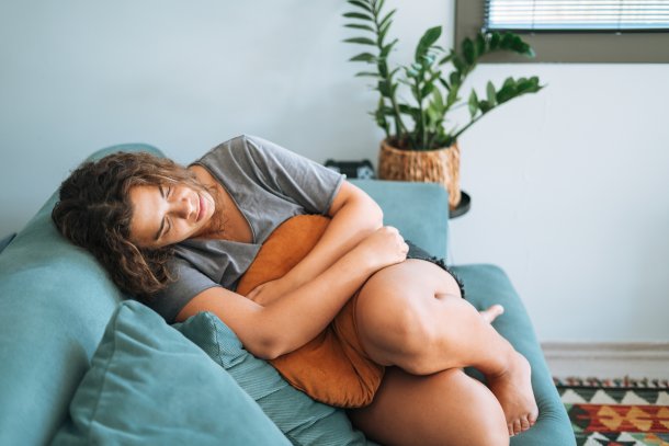 Vrouw voelt zich niet prettig, zit gedeprimeerd op de bank