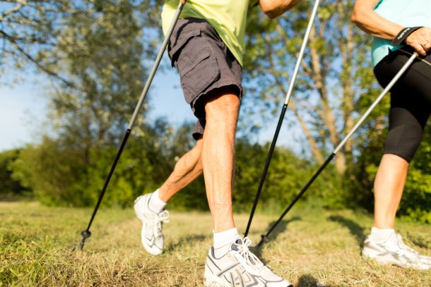 Senior stel doet aan nordic walking in de natuur