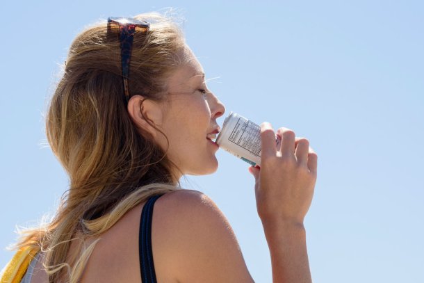 Vrouw drinkt uit een blikje frisdrank met warm weer