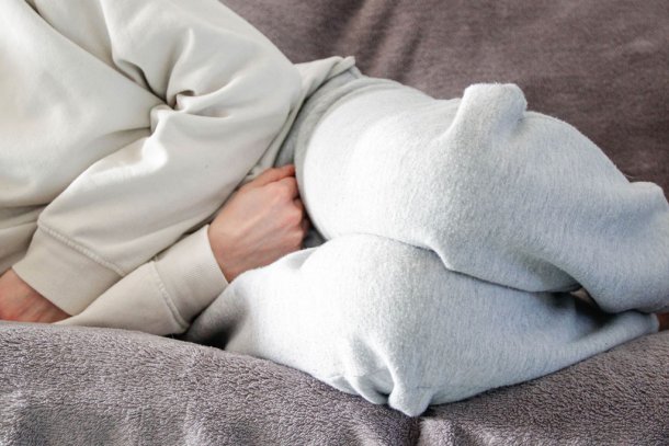 Vrouw ligt op bank met pijn aan het bekken