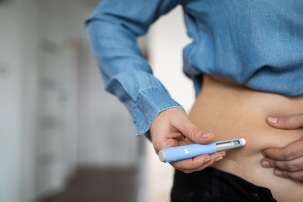 Vrouw spuit afslankmedicatie in haar buik om af te vallen