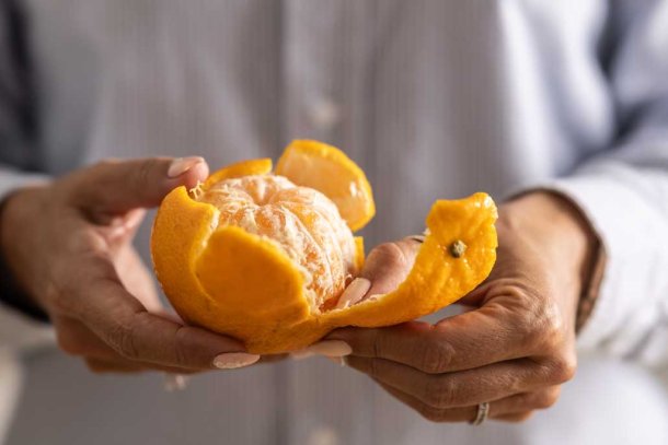 vrouw pelt mandarijn